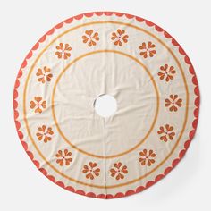 an orange and white circular tablecloth on a white surface with circles in the center