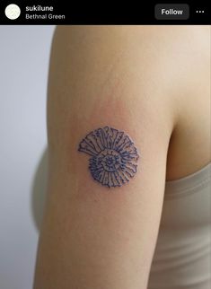 a woman's arm with a tattoo on it that is shaped like a flower