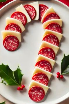 slices of cheese and jelly on a white plate with holly sprigs around it