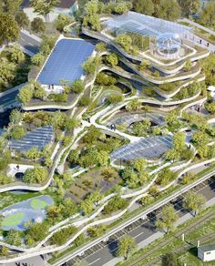 an aerial view of a park with lots of green trees and water features in the center