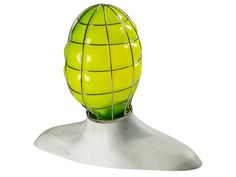 a yellow ball with wire wrapped around it on a white tableclothed surface in front of a gray background