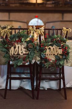 two wooden chairs decorated with christmas wreaths and gold bows are sitting next to each other