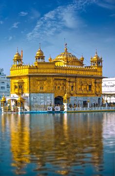 the golden building is reflected in the water