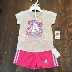 New With Tags! Toddler Girl Adidas Athletic Set. Gray T-Shirt With Pink/Blue/Green/Purple “Adidas” Design; And Bright Pink Shorts With Light Purple Stripes On The Sides. Size 18 Months. 60% Cotton/40% Polyester. Pink Graphic Print Sets For Playwear, Adidas Casual Tops For Playwear, Casual Adidas Tops For Playwear, Pink Adidas Cotton Set, Adidas Pink Cotton Sets, Pink Cotton Adidas Sets, Casual Adidas Sets For Spring, Adidas Pink Playwear Sets, Adidas Pink Sets For Spring