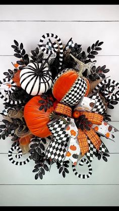 a wreath with pumpkins and black and white decorations