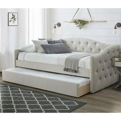 a white daybed sitting on top of a hard wood floor next to a window