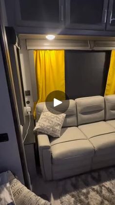 a couch in the corner of a room with yellow curtains