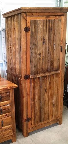 a wooden armoire sitting next to a table with drawers on each side and a cabinet in the middle