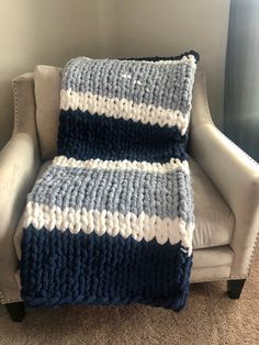 a blue and white crocheted blanket sitting on top of a chair