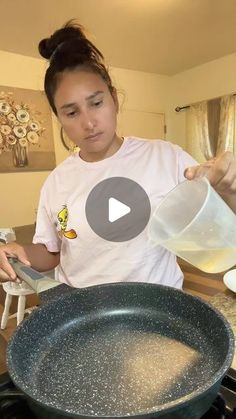 a woman pouring water into a frying pan