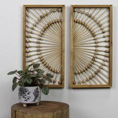 two wooden wall hangings with plants in them