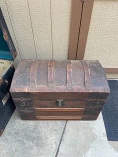 an old trunk sitting on the ground next to a door