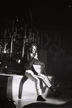 a man sitting on top of a stage holding a microphone