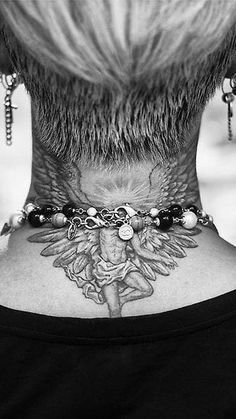 the back of a woman's neck has tattoos on it and is adorned with beads