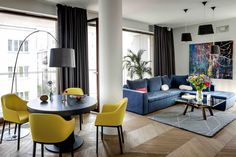 a living room filled with furniture and a painting on the wall above a coffee table