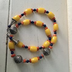 "Yellow glass bead necklace 3 large silver beads with raised design Small red and blue beads 20\" long Yellow beads .5\" long , .26\" wide Condition - very good vintage" Adjustable Amber Beaded Necklace With Large Beads, Amber Beaded Necklaces With Large Beads For Festival, Amber Beaded Necklace With Large Beads For Festival, Spiritual Yellow Jewelry With Large Beads, Polished Oval Beads Necklaces For Festival, Czech Glass Necklaces With Spacer Beads For Festival, Blue Czech Glass Beads For Festivals, Traditional Czech Glass Necklace With Polished Beads, Yellow Necklace With Colorful Oval Beads