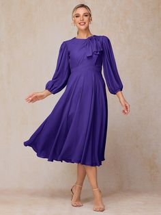 a woman wearing a purple dress with long sleeves and a bow at the neckline