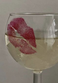 a close up of a wine glass with liquid in it and a lipstick imprint on the side