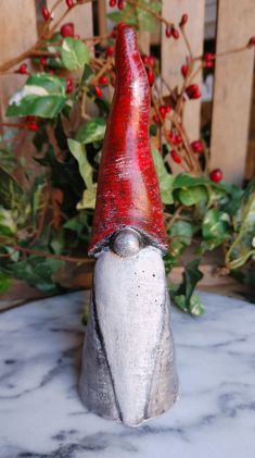 a small red and white gnome's hat sitting on top of a marble slab