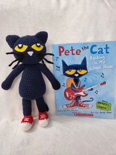 a crocheted cat next to a book about pete the cat