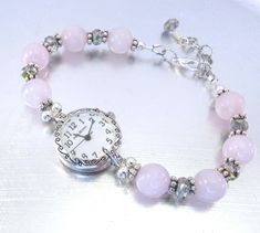 This is an elegant bracelet watch that will compliment many items in your wardrobe. Made with beautiful 10mm pink tourmaline stones that are surrounded by silver tone spacers, and 6mm faceted rondelle vitrail crystal glass that adds magnificent sparkle and shine.  It is strung on super strong Beadalon 49 strand wire, has a lobster claw clasp with a 1" extender chain. Choose your size: Small - 5 1/2"- 6 1/4" Medium - 6 1/4" - 7" Large - 7 1/4" - 8" X-Large - 8"- 8 3/4" If you are interested in a different size or color combination, please contact me to discuss a custom order. The attractive round Narmi watch face has a scroll detail, is silver tone that measures about 22mm, has a stainless steel back and is water resistant. If you purchase a watch in my shop I will also include an extra bat Silver Rose Quartz Bracelet, Elegant Quartz Round Beads Jewelry, Elegant Quartz Beaded Jewelry, Classic Adjustable Pink Bracelets, Adjustable Classic Pink Bracelets, Pink Bracelet Strap Jewelry For Formal Occasions, Pink Bracelet Style Jewelry For Formal Occasions, Formal Pink Jewelry With Bracelet Strap, Elegant Rose Quartz Crystal Bracelet