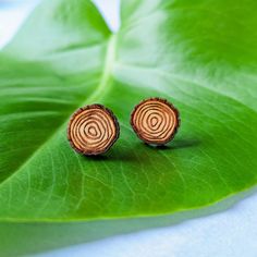 These minimalist tree ring stud earrings are a simple, rustic accessory for men or women. The studs are laser-etched on cherry wood to look like the cross-section of a tree and make a great gift for nature lovers or lumberjacks! These earrings feature hypoallergenic 316 surgical stainless steel studs with butterfly back closures and are sealed with a semi-gloss varnish on the front for protection and durability. The back is unstained and unsealed cherry wood. Love this set? You may also like the Minimalist Jewelry In Natural Tones As A Gift, Natural Color Nature-inspired Round Jewelry, Nature-inspired Round Natural Jewelry, Round Wood Jewelry As A Gift, Round Wooden Jewelry For Gifts, Hypoallergenic Nature-inspired Earrings For Gifts, Round Wooden Jewelry Gift, Nature Stud Earrings, Adjustable Nature-inspired Wooden Jewelry