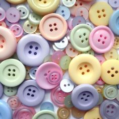 many different colored buttons on a white surface