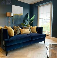 a living room with blue couches and gold pillows