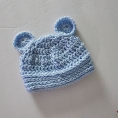 a crocheted blue hat with ears is laying on the floor next to a wall