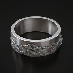 Celebrate your love for the great outdoors with this beautifully crafted Mountain Range Wedding Band in 925 Sterling Silver. Featuring an intricate landscape design of majestic mountain peaks, this ring is perfect for nature lovers, hikers, or anyone with a passion for adventure. Its durable silver construction ensures lasting quality, making it a great choice for daily wear or special occasions. The unique design symbolizes the strength and beauty of nature, making it a meaningful piece for weddings, anniversaries, or as a thoughtful gift for your adventurous partner. Available in various sizes to ensure the perfect fit, this ring captures the essence of the wilderness and the spirit of exploration. ⚜️ Package included: Unisex Silver Ring - Made to order ⚜️ Sizes: From 3 to 15 US ⚜️ Mater Mountains Ring, Viking Ring, Masonic Ring, Retro Ring, Animal Rings, Everyday Rings, Cross Ring, Handmade Rings, Gifts For Brother