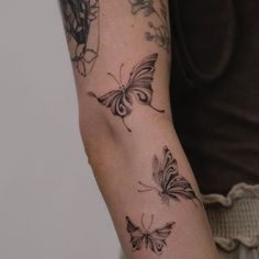 a woman's arm with three butterflies on it