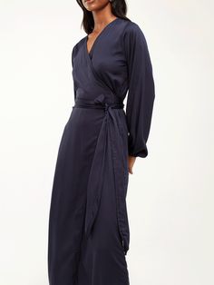 Elevate your everyday wardrobe with the Lala Midi Dress in Solid Navy, a timeless wrap dress handcrafted in Dakar, Senegal. Featuring elasticized sleeves and crafted from sustainable 100% lyocell satin, this dress offers effortless style and comfort in a bold, versatile color. Wrap dress Elasticized sleeves Handcrafted in our small atelier in Dakar, Senegal 100% lyocell satin Midi length Sizes range from XS to 3XL Small Atelier, Dakar Senegal, Midi Wrap Dress, Plus Size Pants, Swimsuit Tops, Everyday Wardrobe, Effortless Style, Midi Length, Custom Color