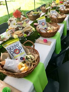 a table set up with baskets and food on it for an outdoor party or gathering