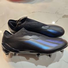 a pair of black and blue soccer cleats sitting on top of a table