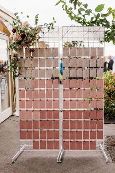 an outdoor wedding ceremony with wooden blocks and flowers on the back wall, surrounded by greenery