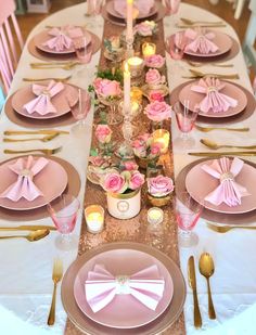 the table is set with pink and gold place settings