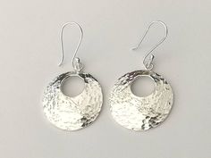 These beautiful silver earrings are approximately 2.5cm diameter with a 1cm hole cut out. They are hammered and domed. They are .9 mm thick so not overly heavy and they look fab on. I also do a necklace to match these or instead of. All made with 925 sterling silver. Hammered Silver Circle Earrings, Hammered Sterling Silver Round Earrings, Silver Hammered Circle Earrings, Sterling Silver Hammered Round Earrings, Hammered Silver Round Disc Earrings, Silver Hammered Round Earrings, Hammered Earrings, Silver Spinner Rings, Feather Pendant