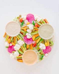 an overhead view of various vegetables and dips on a platter