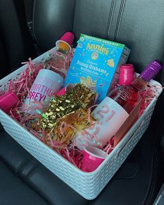 a white basket filled with lots of bottles and confetti on top of a car seat