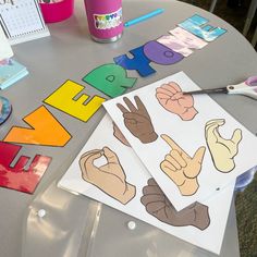 the table is set up with paper cutouts and scissors to make hand signals for children