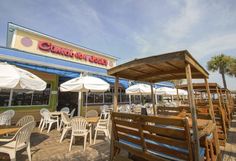 an outdoor dining area with tables and umbrellas on the deck at golden duck's