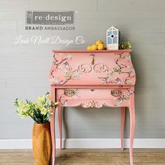 an old pink piano is next to a vase with lemons and flowers on it