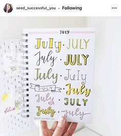 someone is holding up a spiral notebook with the words july and july written on it