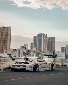 a race car driving down the road in front of tall buildings