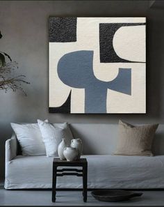 a white couch sitting under a painting on the wall