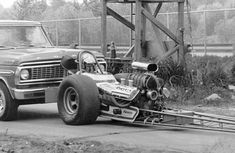 an old truck pulling a small engine on the back of it's flatbed