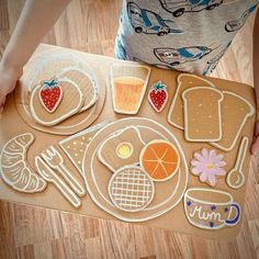 a child is making cookies and other food items on a table with a cutting board