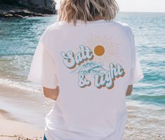 This Salt and Light T-shirt is perfect for those who love the beach, surfing, sunshine, sand, and Jesus!    PRODUCT INFO Comfort Colors 1717 UNISEX relaxed fit,100% ring-spun cotton T-shirt, soft-washed, garment-dyed fabric, double-needle stitching, no side seams.   Your graphic will be printed direct to garment (DTG). This means that the ink will be embedded into the fabric itself and last much longer than a heat transfer image as well as be much softer to the touch.   SIZING Please refer to the sizing chart to find your perfect fit. For an oversized look, please go up 2 or 3x your normal size according to your needs.   RETURNS AND EXCHANGES These sweatshirts are immediately sent to print once you complete the purchase, no changes can be made once this happens. Because this is a custom ma White T-shirt With Text Print For Summer Adventures, Surfing T-shirt With Front Print For Beach Season, Beach Season Surfing T-shirt With Front Print, Surfing Beach Season T-shirt With Front Print, Relaxed Fit T-shirt For Surfing Beach Season, White Vsco T-shirt For The Beach, White Sublimation Print T-shirt For Beach Season, White T-shirt With Sublimation Print For Beach Season, White Vsco Style T-shirt For Beach