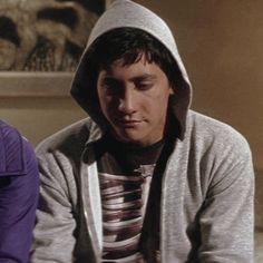 a man in a hoodie sitting next to another person