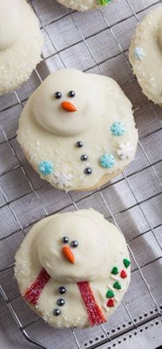 frosted snowman cookies sitting on top of a cooling rack